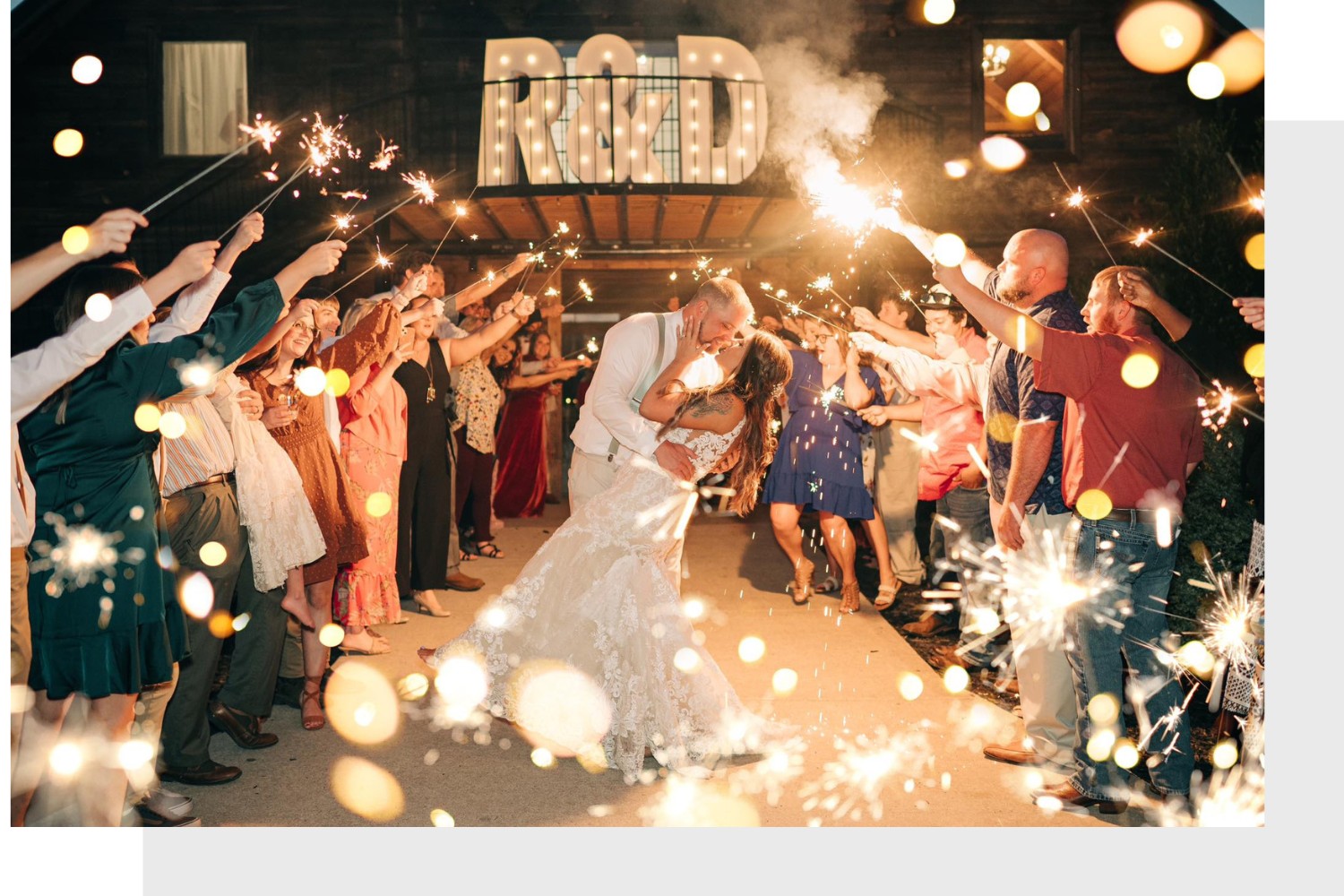 bride and groom kissing during sparkler exit