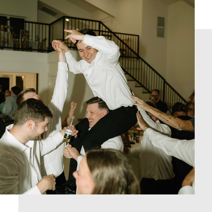 groom on groomsmen's shoulders on dance floor