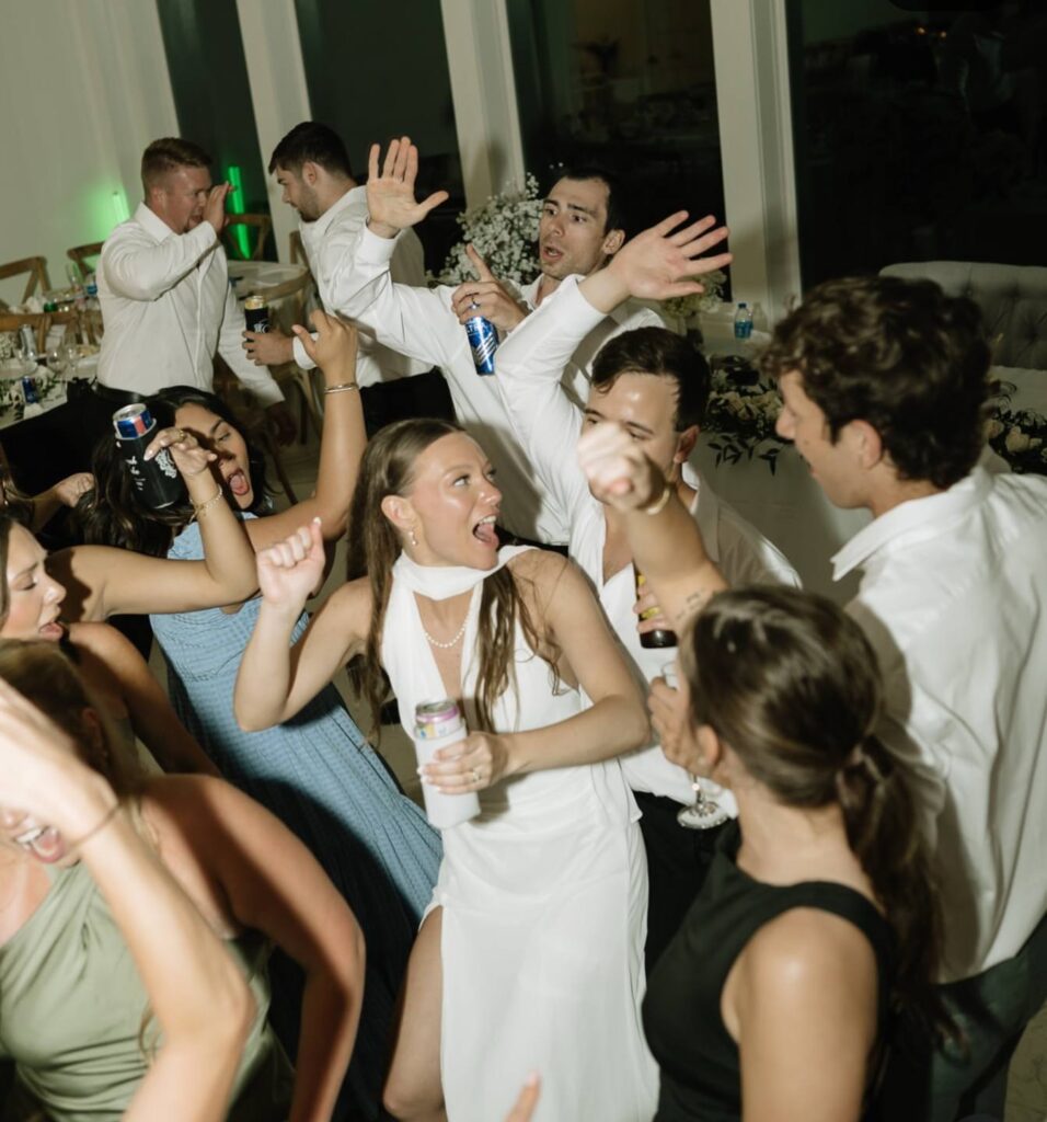 bride and groom with wedding guests on dance floor