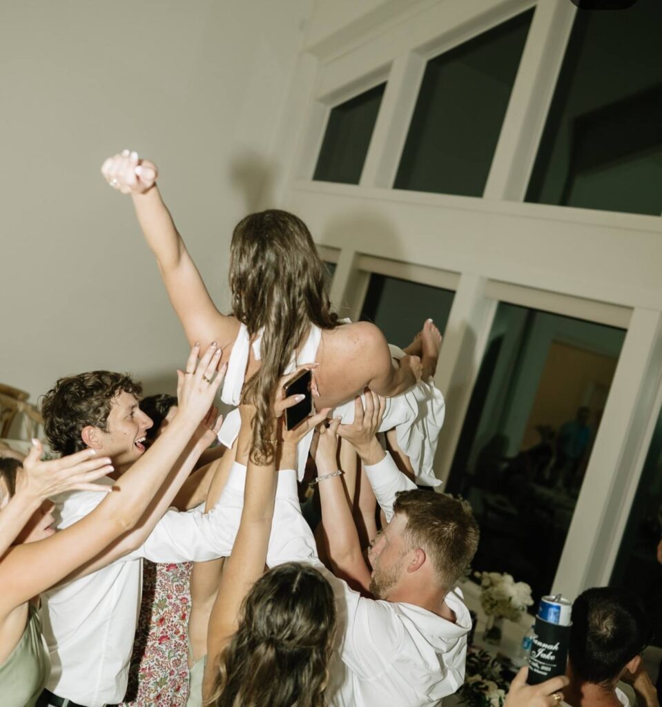 wedding guests lifting bride on dance floor