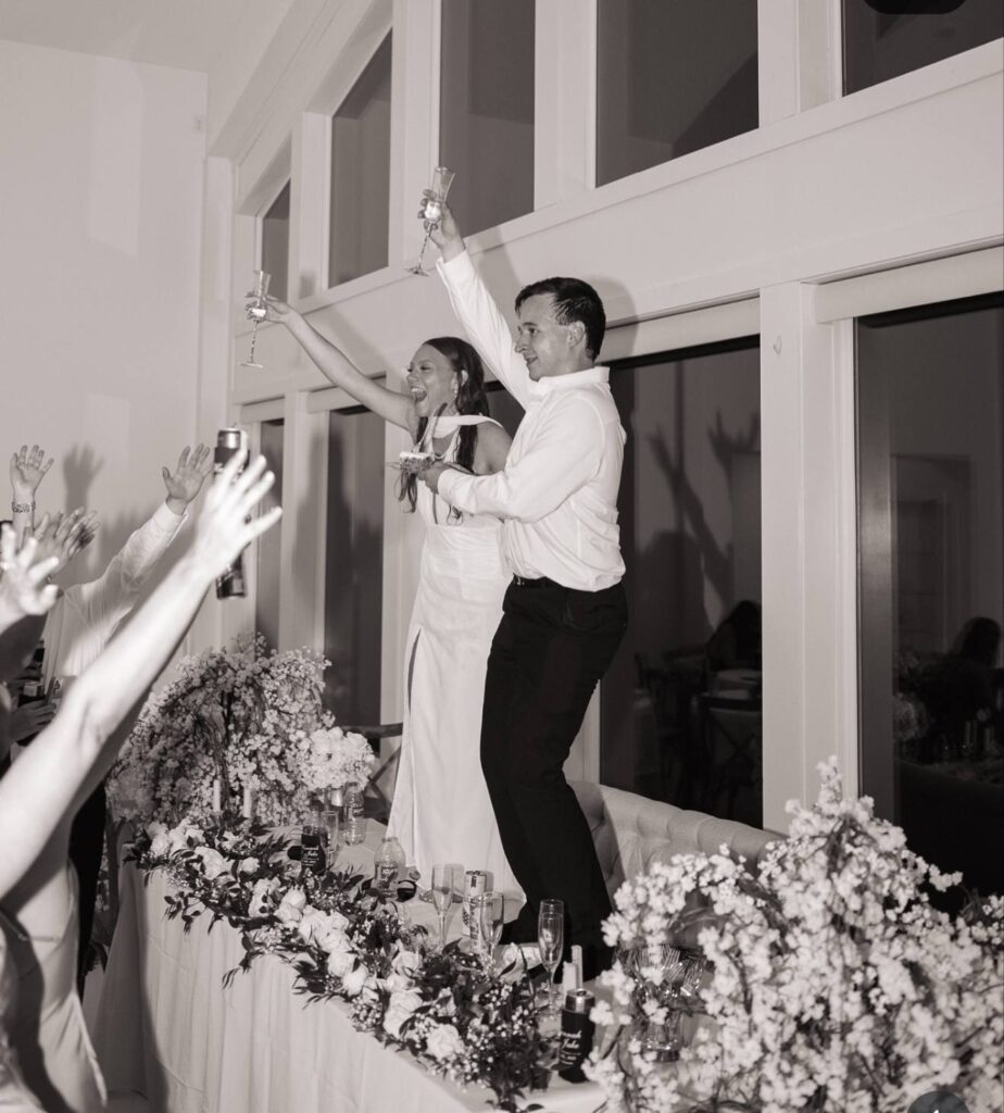 bride and groom dancing on table