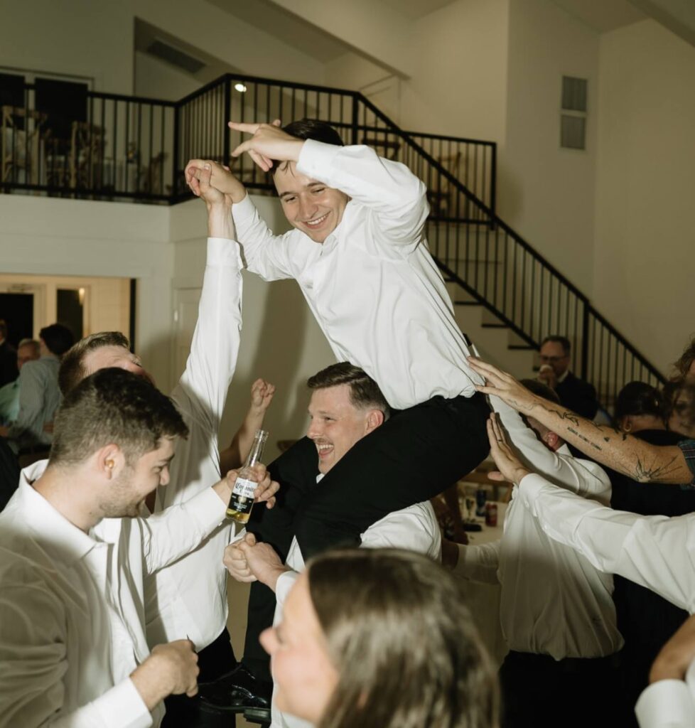 groom on groomsman's shoulders on dance floor